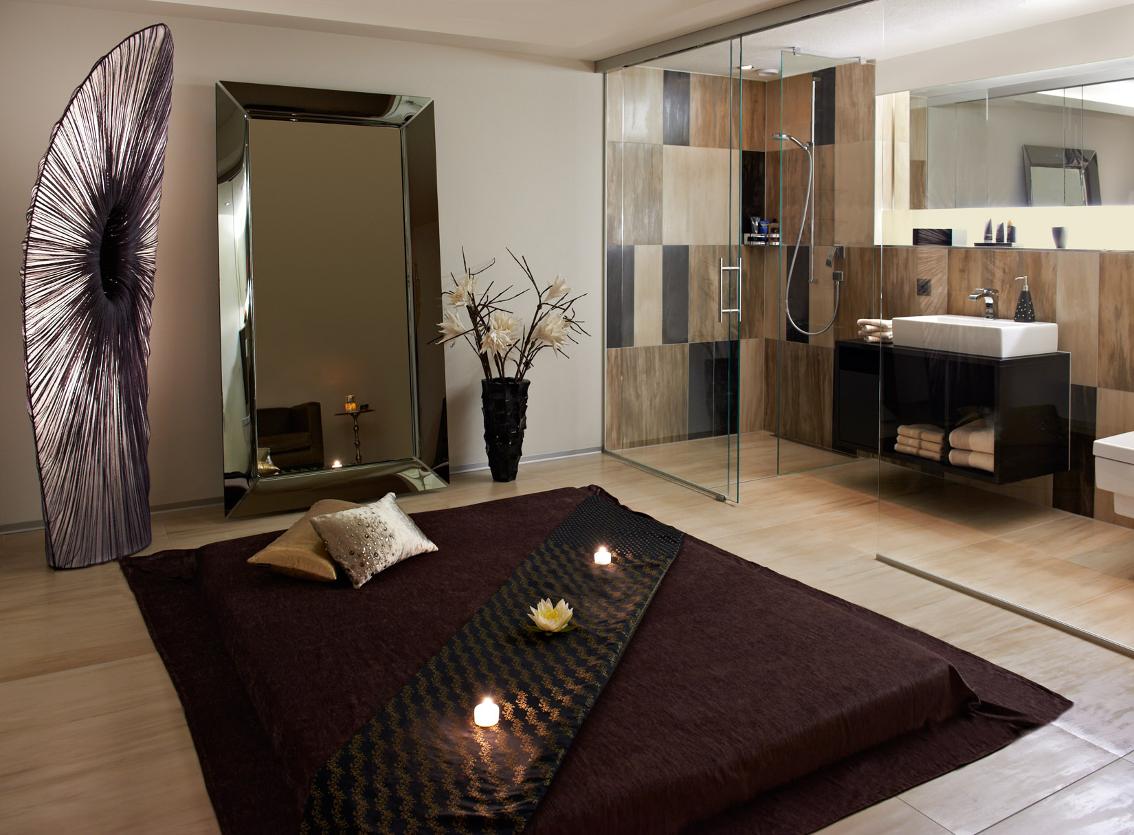Massageraum mit Futon am Boden, im Hintergrund elegantes Bad